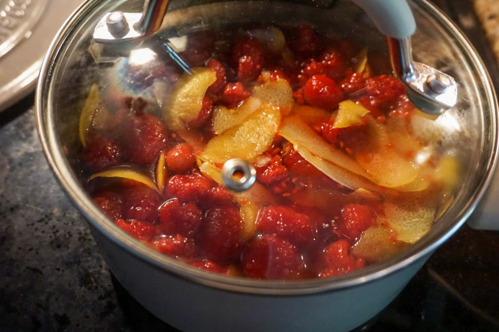 steaming raspberries and lemon peels with boiled sugar water