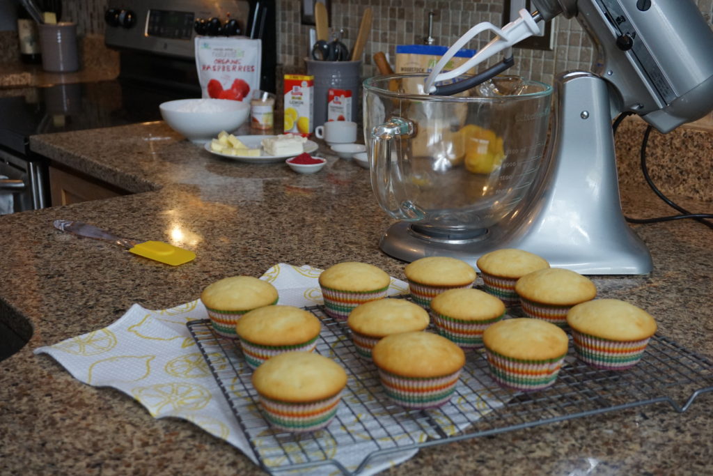 Baked lemon cupcakes cooling down on a cooling rack before frosting. 