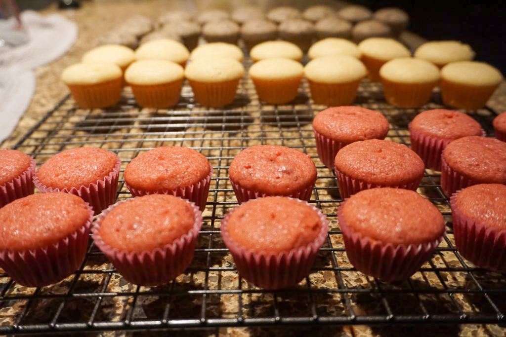 all the flavored cupcakes on a cooling rack 