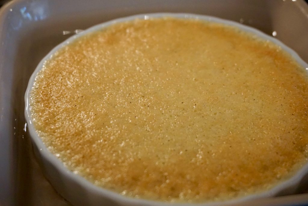 Baked creme brûlée custard with crisp edges and still slightly wiggling center. 