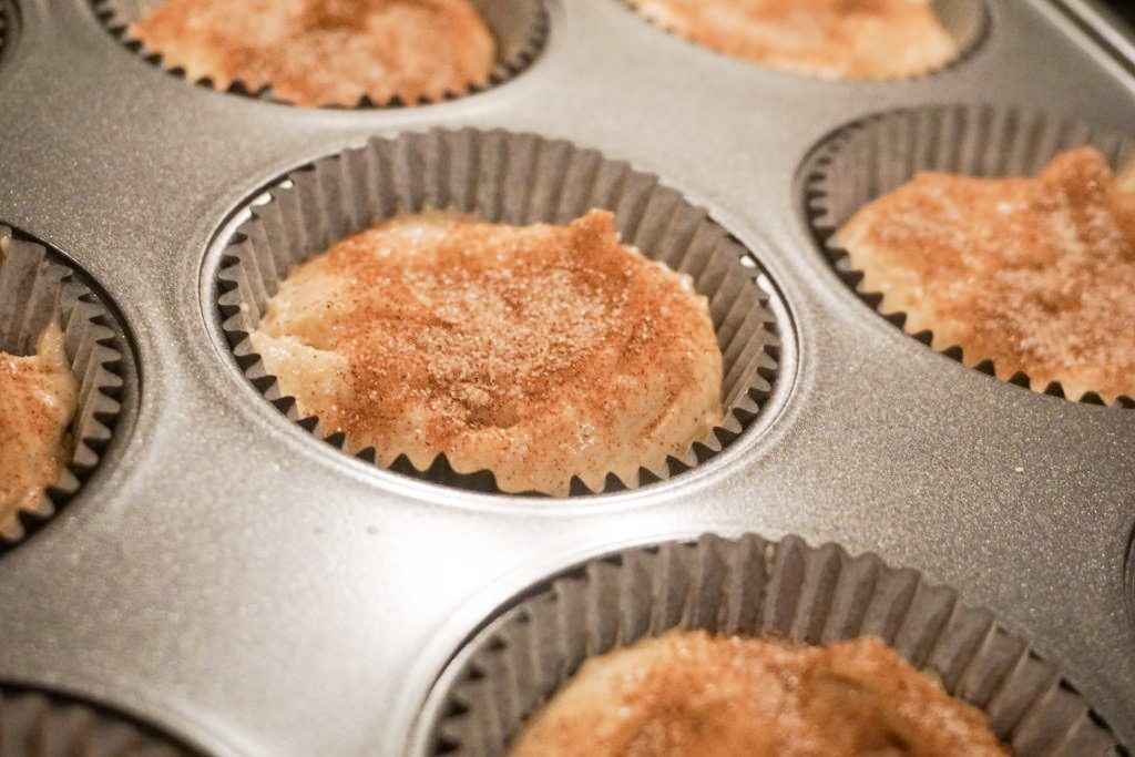 Unbaked snickerdoodle cupcakes with the sprinkle of cinnamon sugar on top