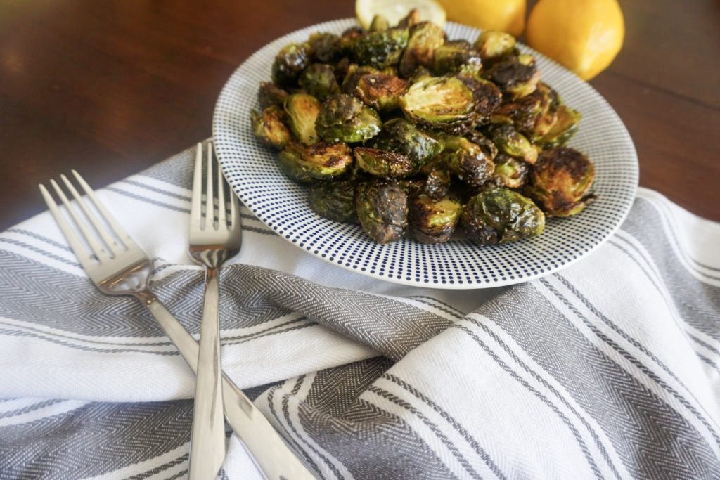 Delicious plated brussels sprouts with two forks and lemons 