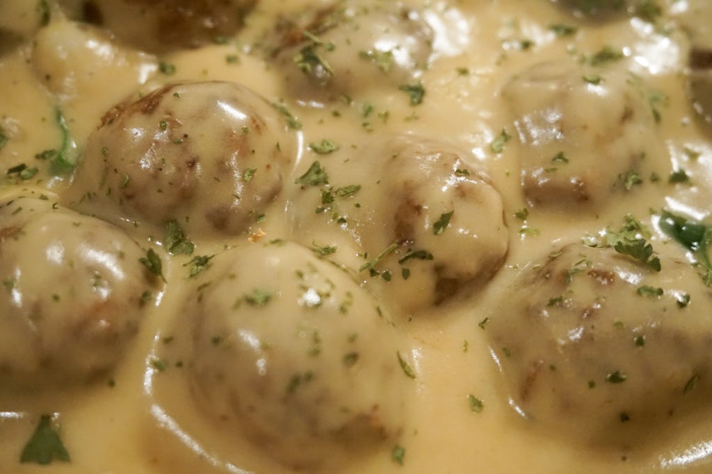 Close up of the gravy with the Swedish meatballs and fresh finely chopped parsley 