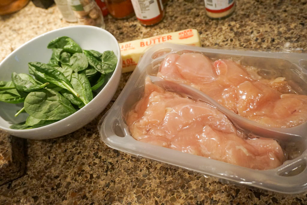 Uncooked spinach and raw previously chopped chicken breast