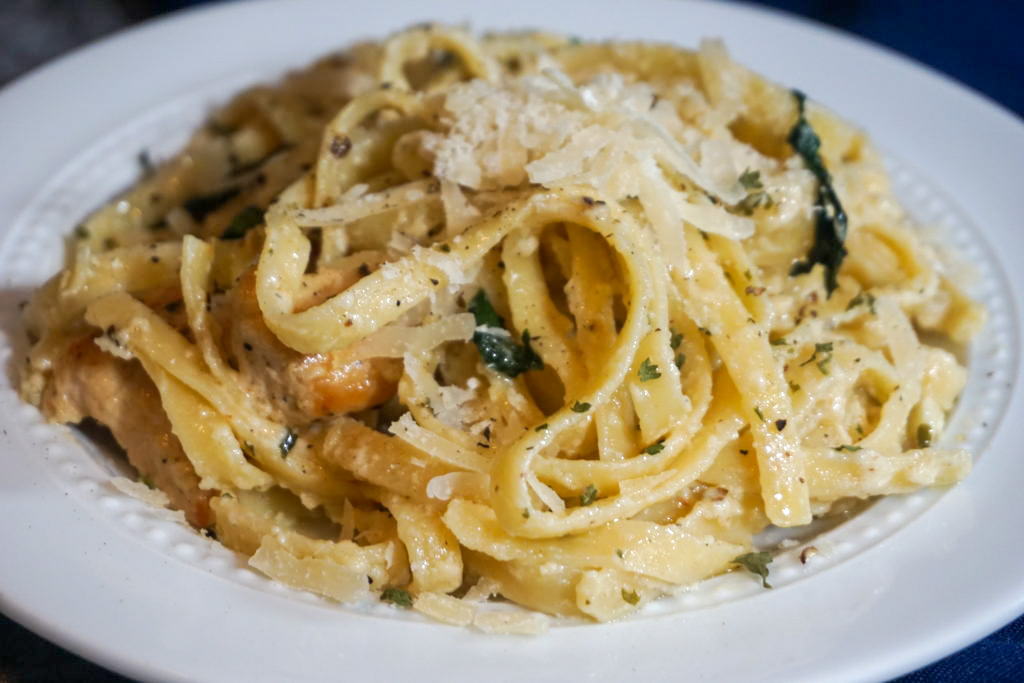 Close-up of the plated fettuccine Alfredo with grilled chicken and spinach