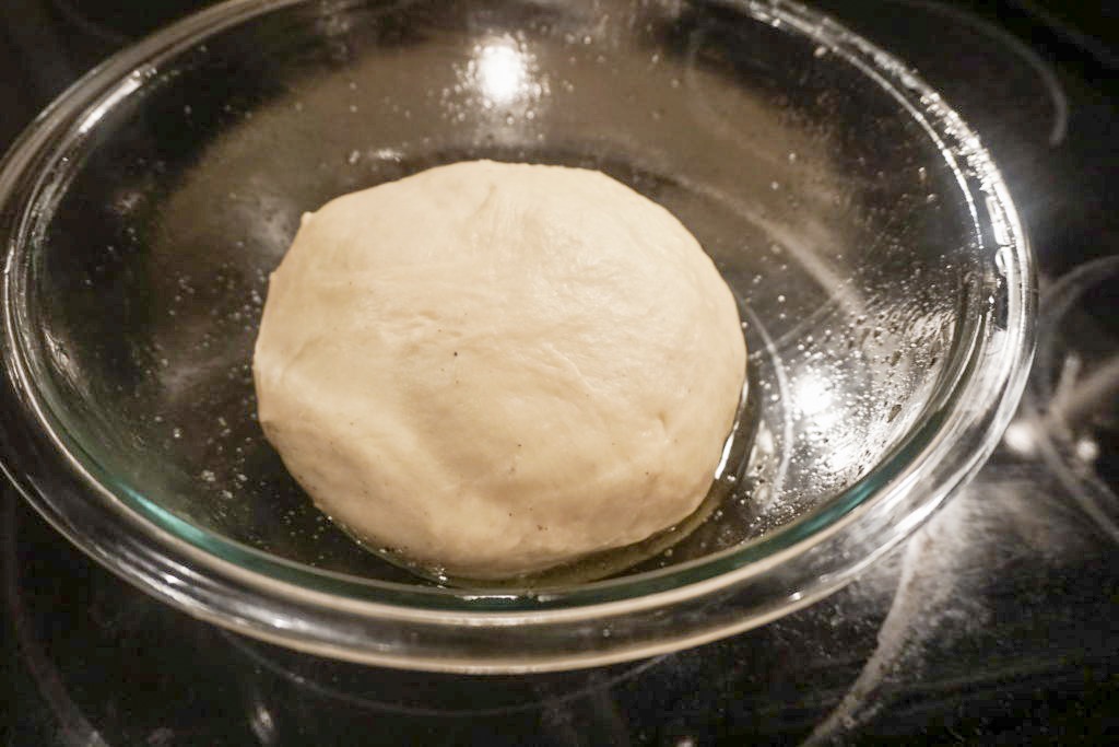 Close-up of the brioche dough in the greased glass bowl