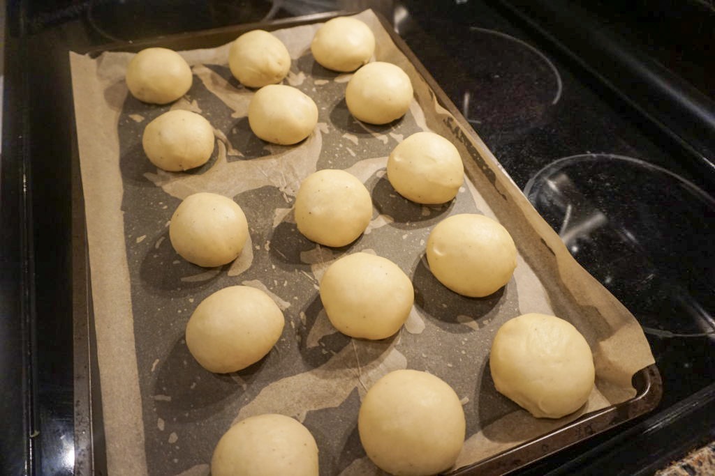 Displaying all the brioche dinner rolls unbaked on a lined cookie sheet