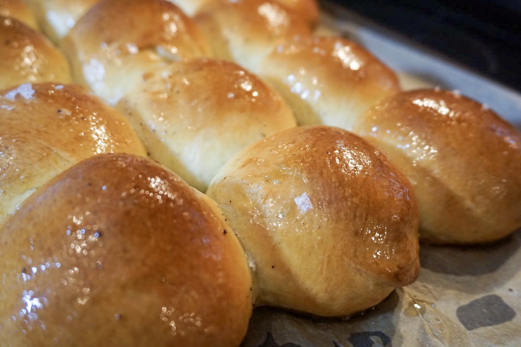 Close-up of the brioche dinner rolls baked with brown butter drizzled on top