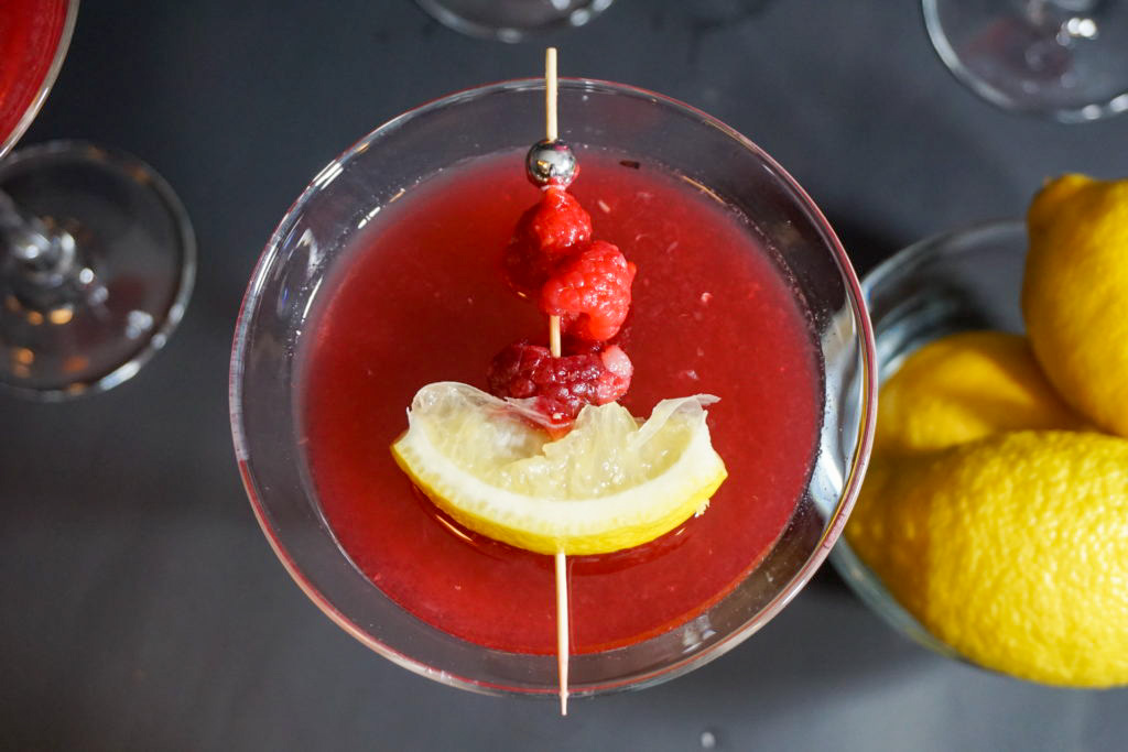 the raspberry martini with fresh raspberry and lemon slice on a stick 