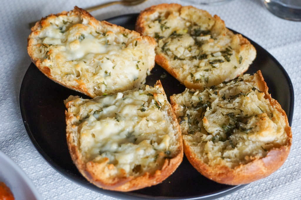 Garlic bread and cheesy garlic bread placed on a black plate