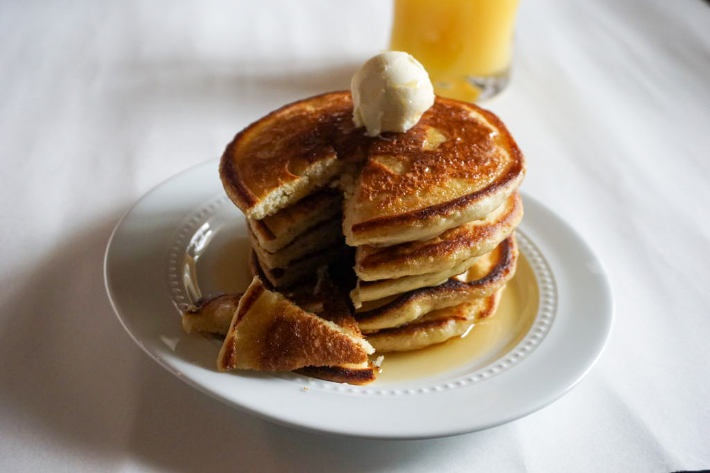 the buttermilk pancakes with syrup, butter, and orange juice 