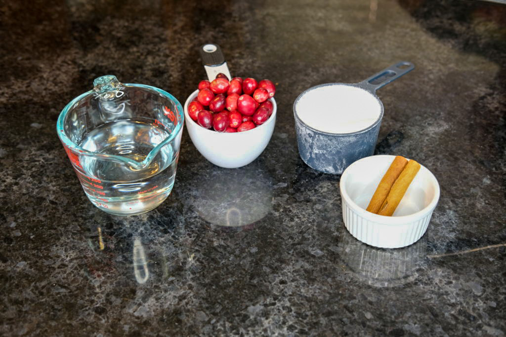 the  ingredients to the simple syrup: water, cinnamon sticks, sugar, and cranberries 