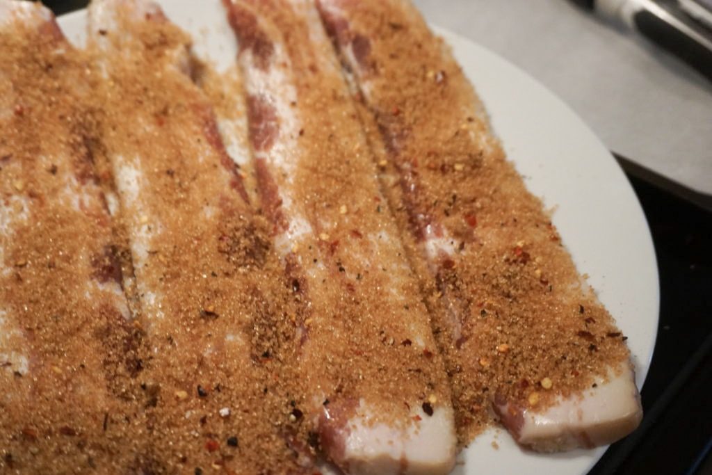 Raw bacon with the brown sugar and spice mixture 