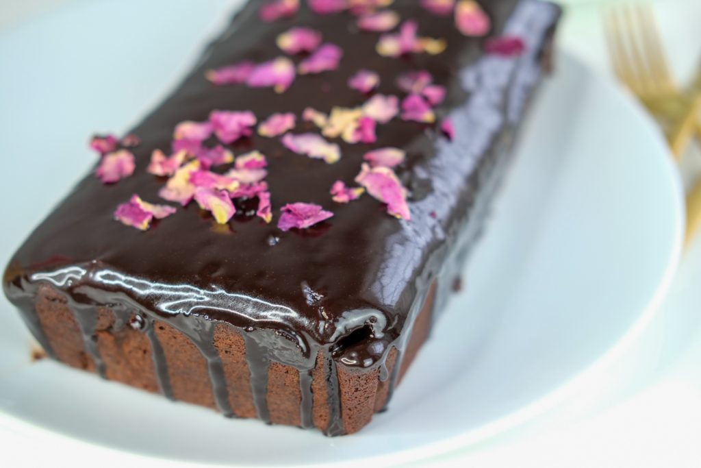 the chocolate pound cake with a chocolate drizzle, edible roses and gold forks