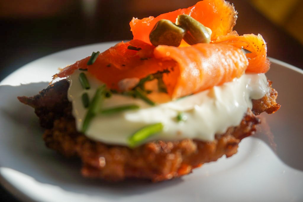 potato cakes with Crème fraîche, chives, capers, and smoked salmon on top